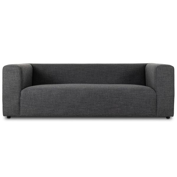 Sofa tapicerowana o miekkim zarysie z oszczednym detalem w odcieniu czerni